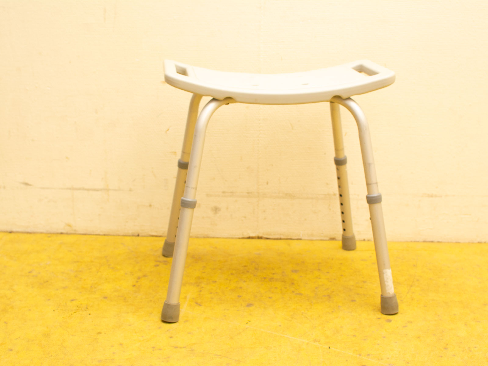 Stylish adjustable stool with beige seat and metallic frame, perfect for any home or workspace.