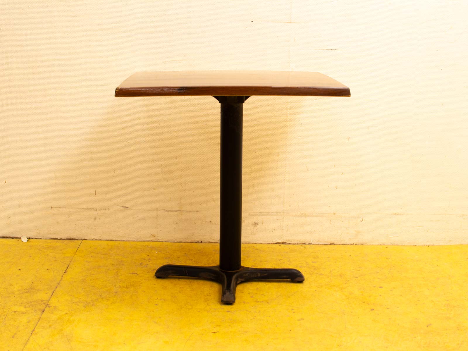 Stylish wooden table with black metal base, perfect for modern homes and cafes.