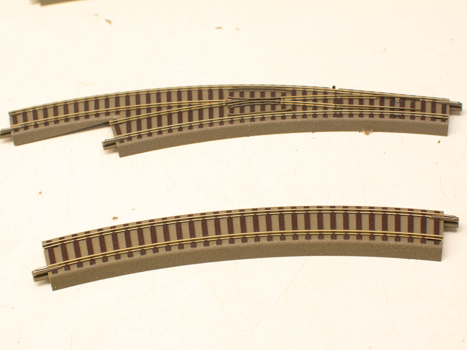 Curved model train tracks showcasing detailed metallic rails and wooden ties for realistic setups.