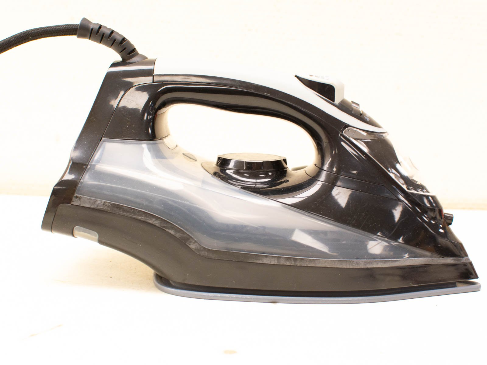 Sleek black steam iron with ergonomic design, precise tip, textured grip, and clear water level window.