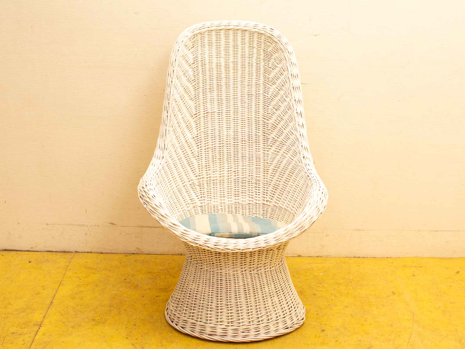 Contemporary white woven chair with striped cushion for stylish comfort in any space.