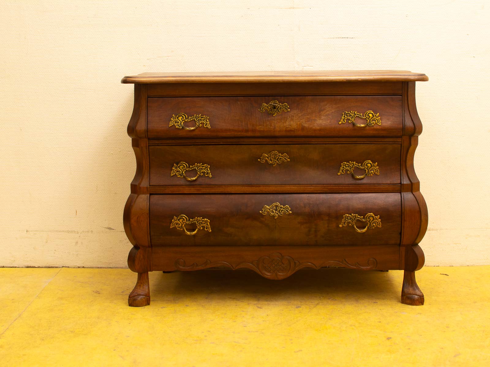 Elegant dark wood chest of drawers with ornate brass handles, perfect for any stylish space.