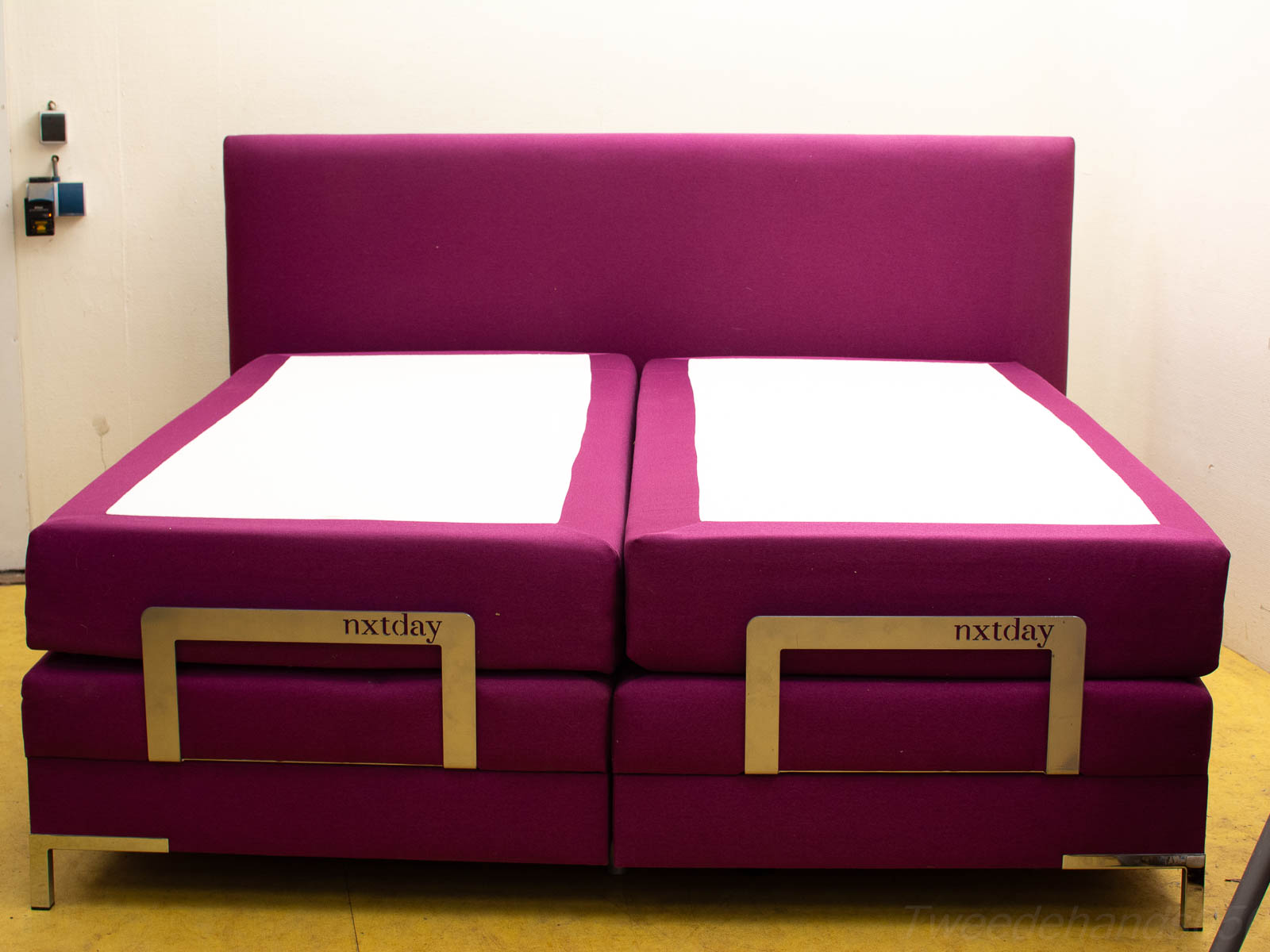 Modern purple bed with plush headboard and sleek metal base for stylish bedroom decor.