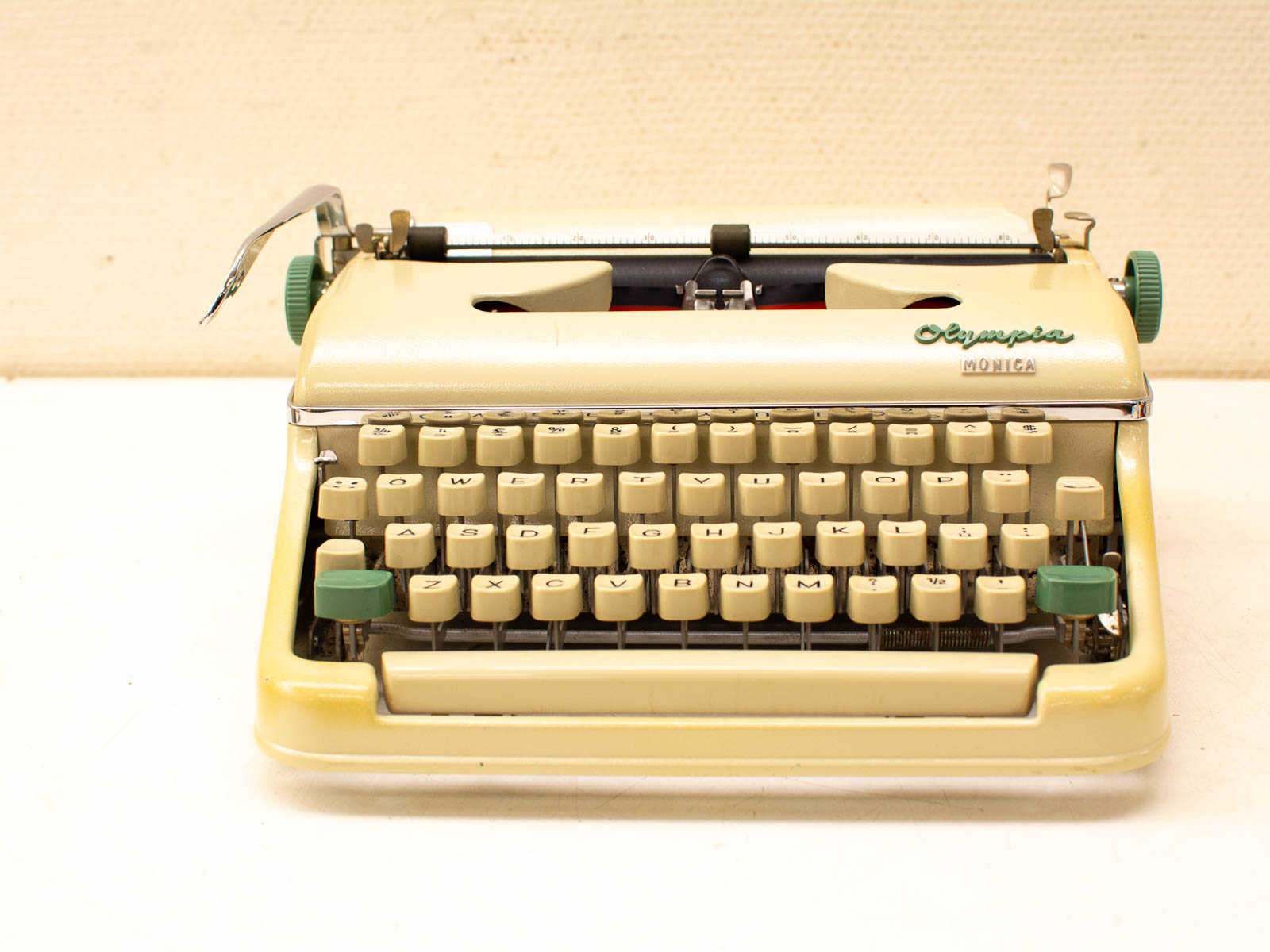 Vintage Olympia Monica typewriter in beige and green, a nostalgic piece of classic writing equipment.