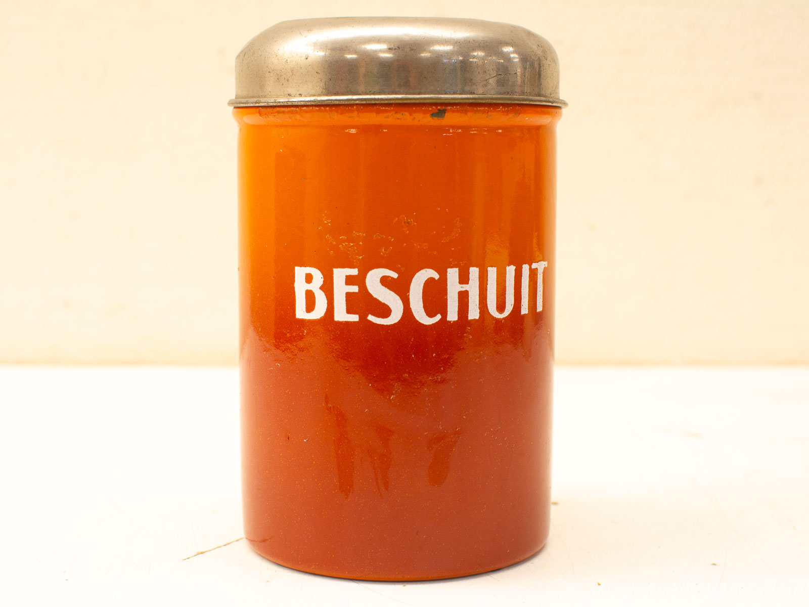 Vintage orange Beschuit glass container with silver lid, perfect for Dutch biscuit storage and kitchen decor.