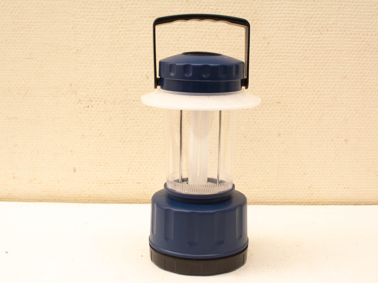 Durable blue outdoor lantern with transparent body for camping and emergency lighting.