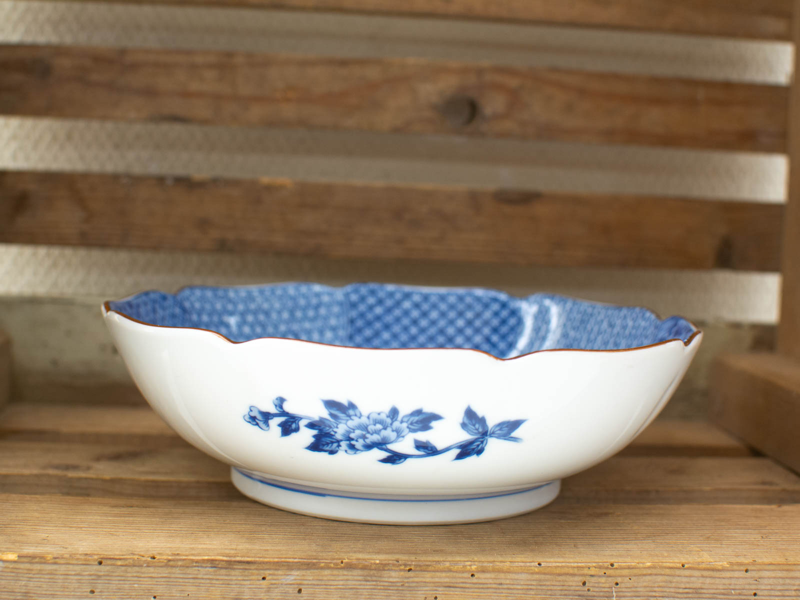 Elegant porcelain bowl with blue floral design and gold rim, perfect for serving or display.