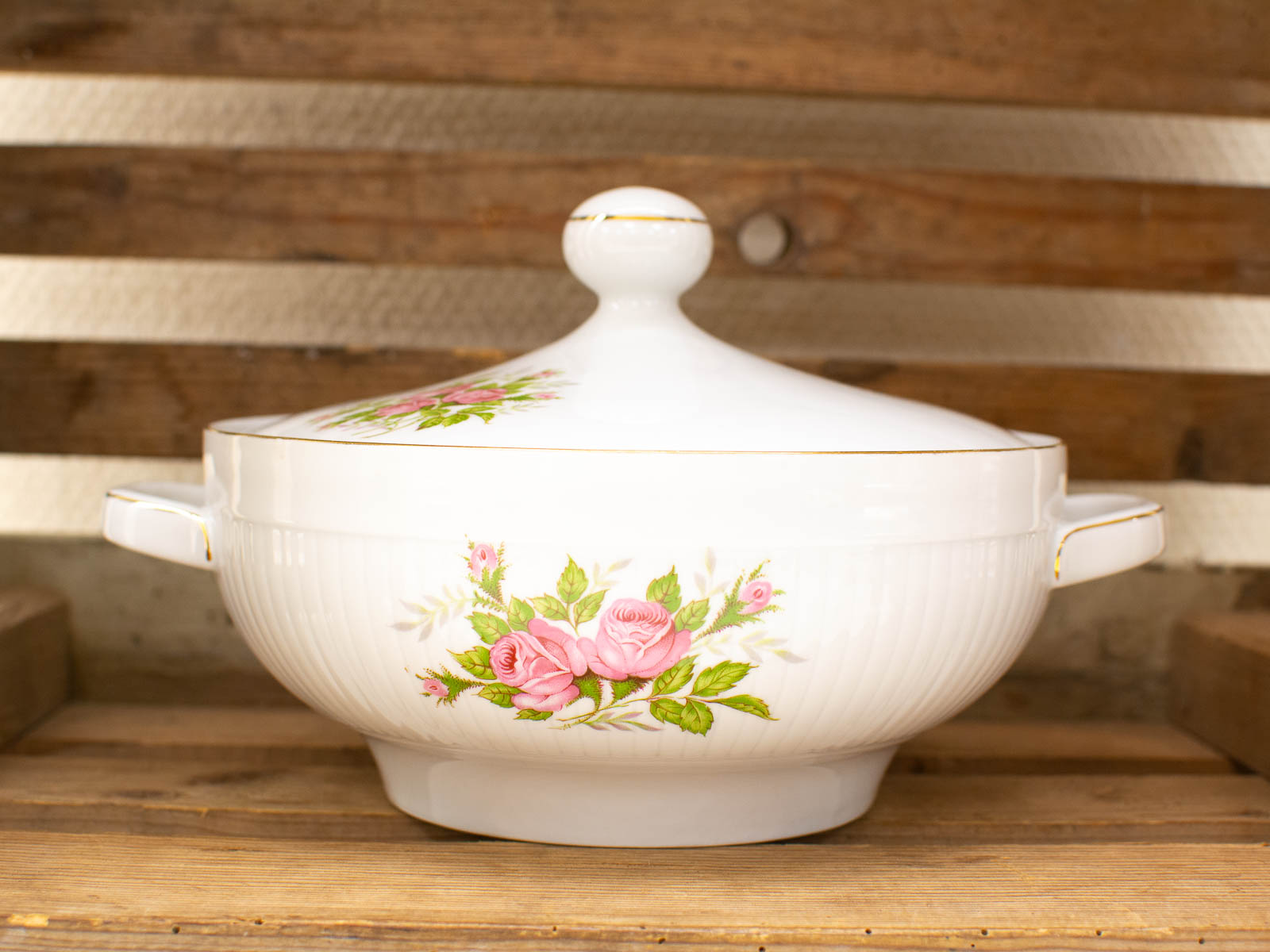 Elegant porcelain tureen with pink roses and gold accents, perfect for any table setting.