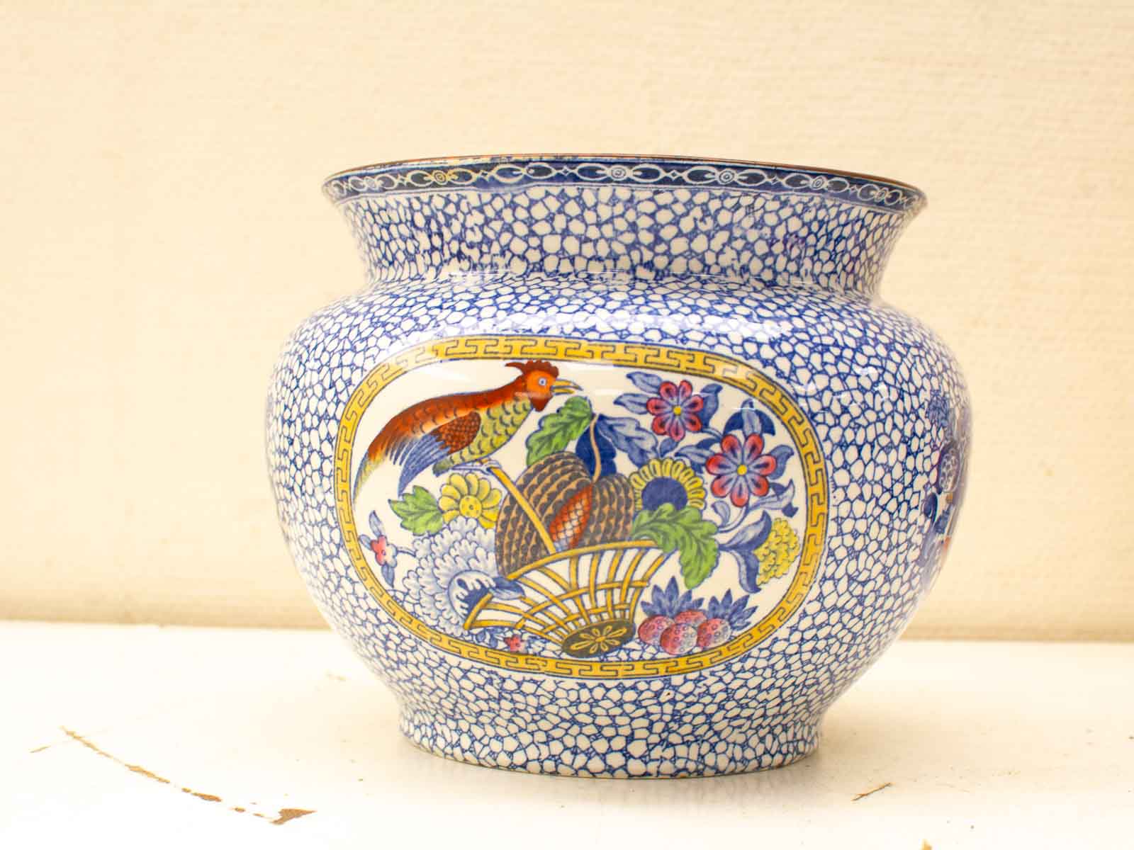 Elegant ceramic vase featuring a colorful bird and floral design, perfect for decorative purposes.