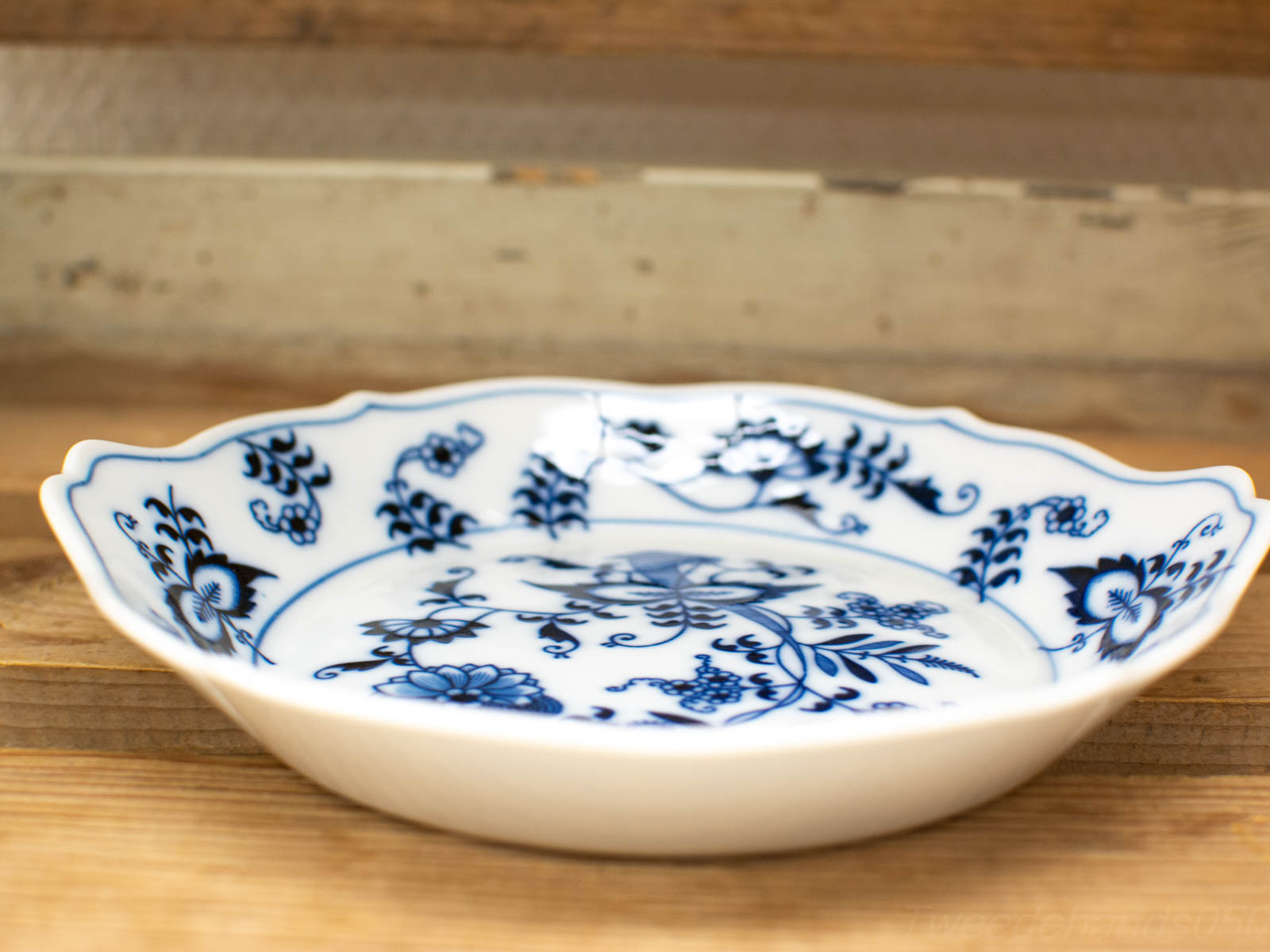 Elegant blue and white porcelain plate with floral design and scalloped edge. Timeless decor piece.