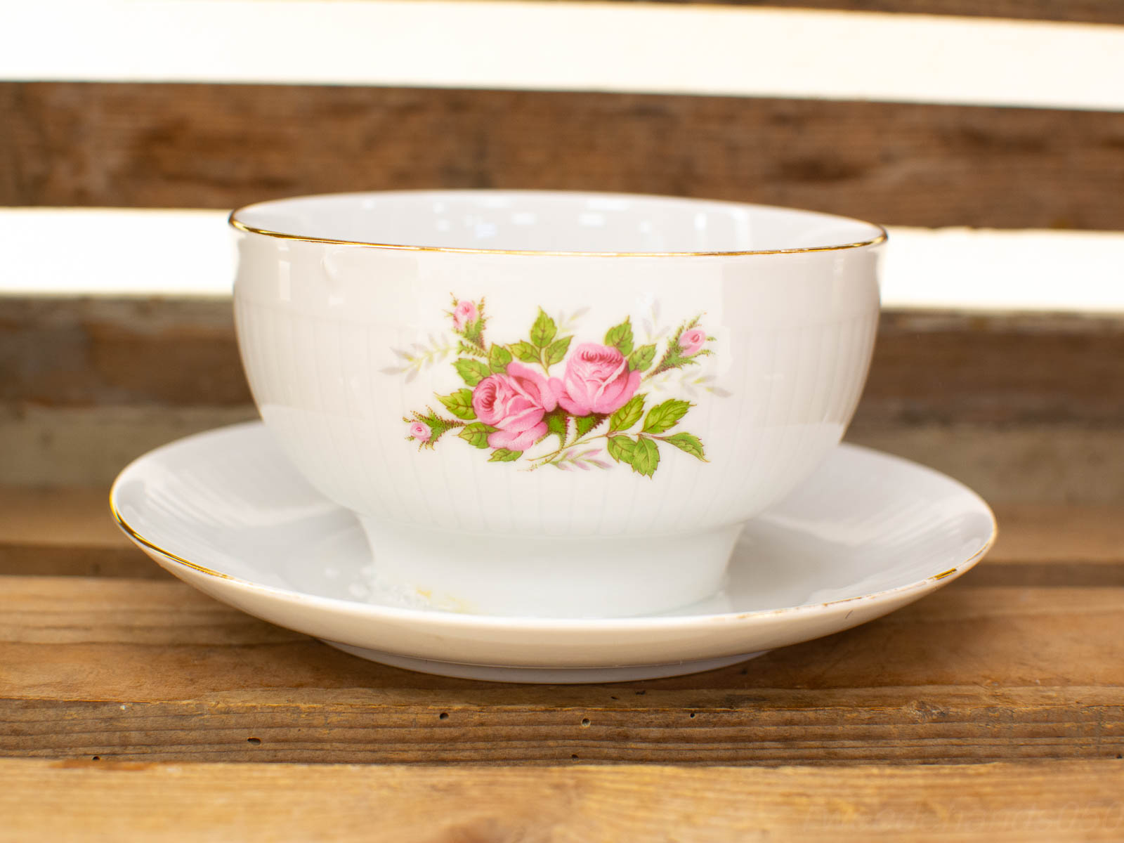 Elegant porcelain bowl and saucer with pink roses and gold trim for stylish dining.