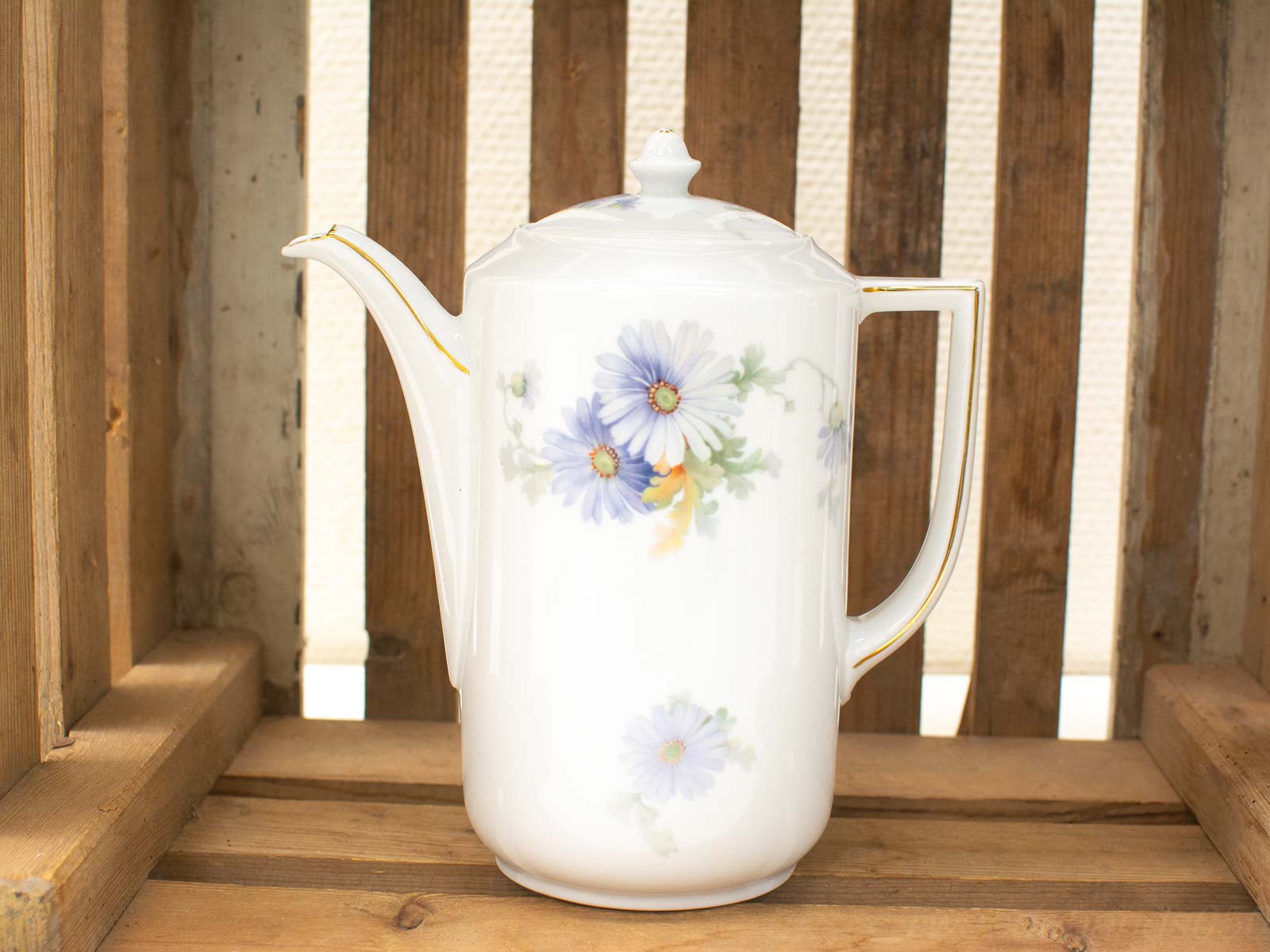 Elegant porcelain coffee pot with blue daisy motifs, perfect for display and nostalgic gatherings.