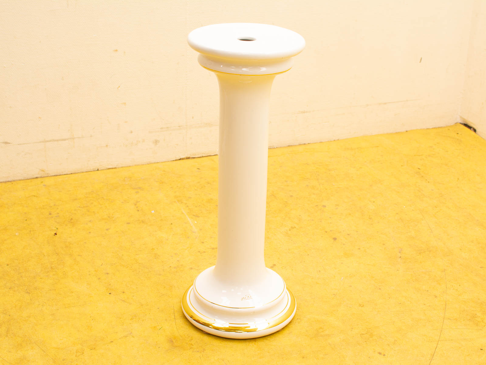 Elegant white ceramic pedestal with gold trim, ideal for showcasing decorative pieces.