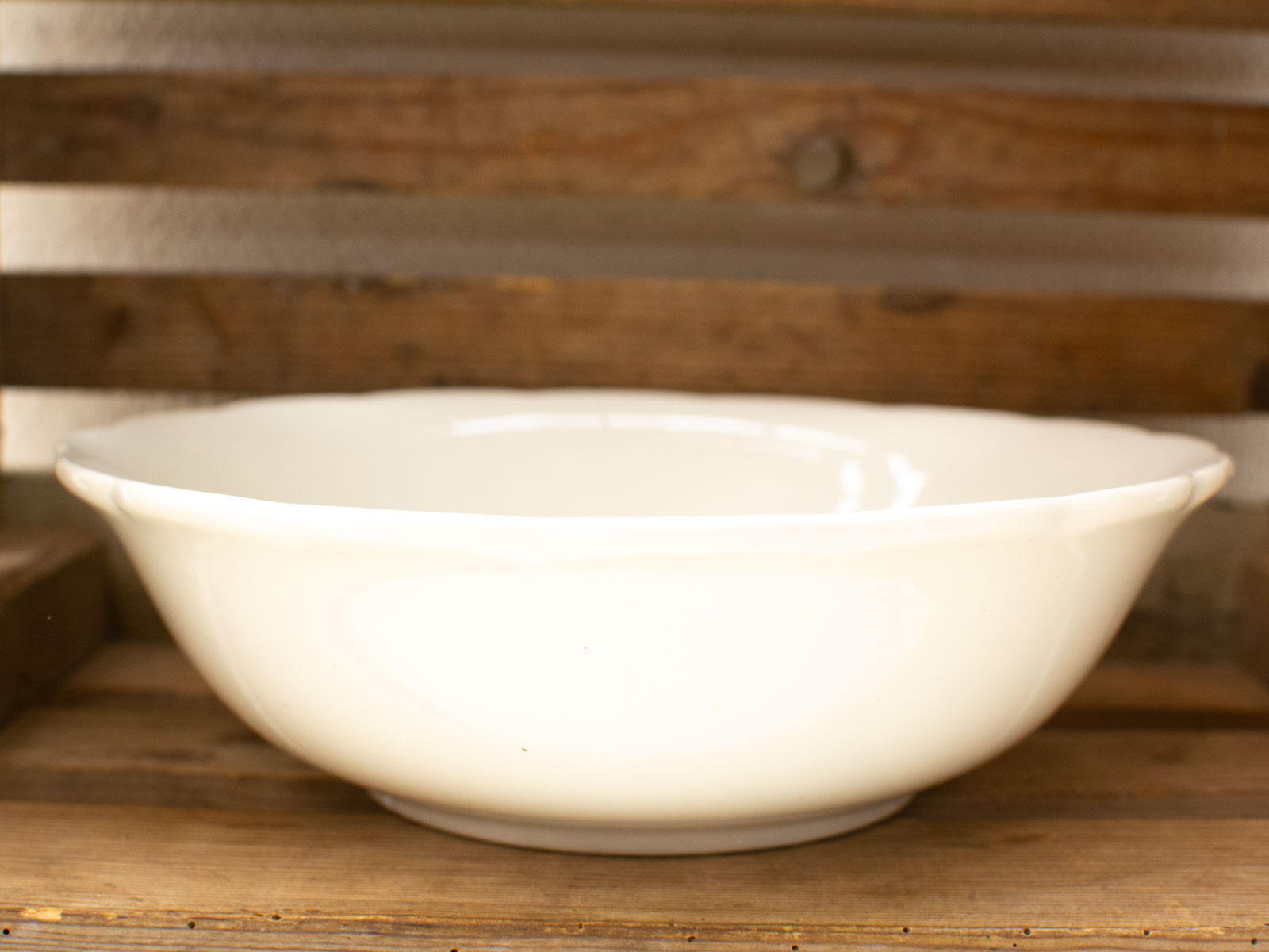 Elegant white ceramic bowl on rustic wood, blending traditional and modern design.