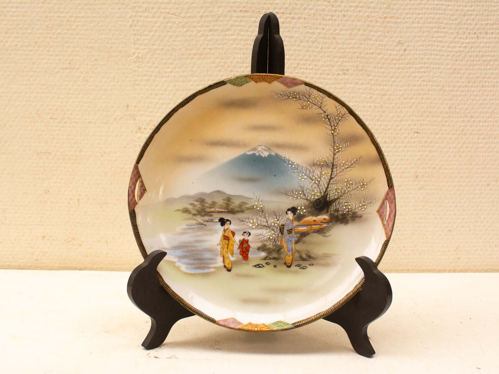 Japanese art-inspired decorative plate featuring Mount Fuji, cherry blossoms, and traditional kimono-clad figures.