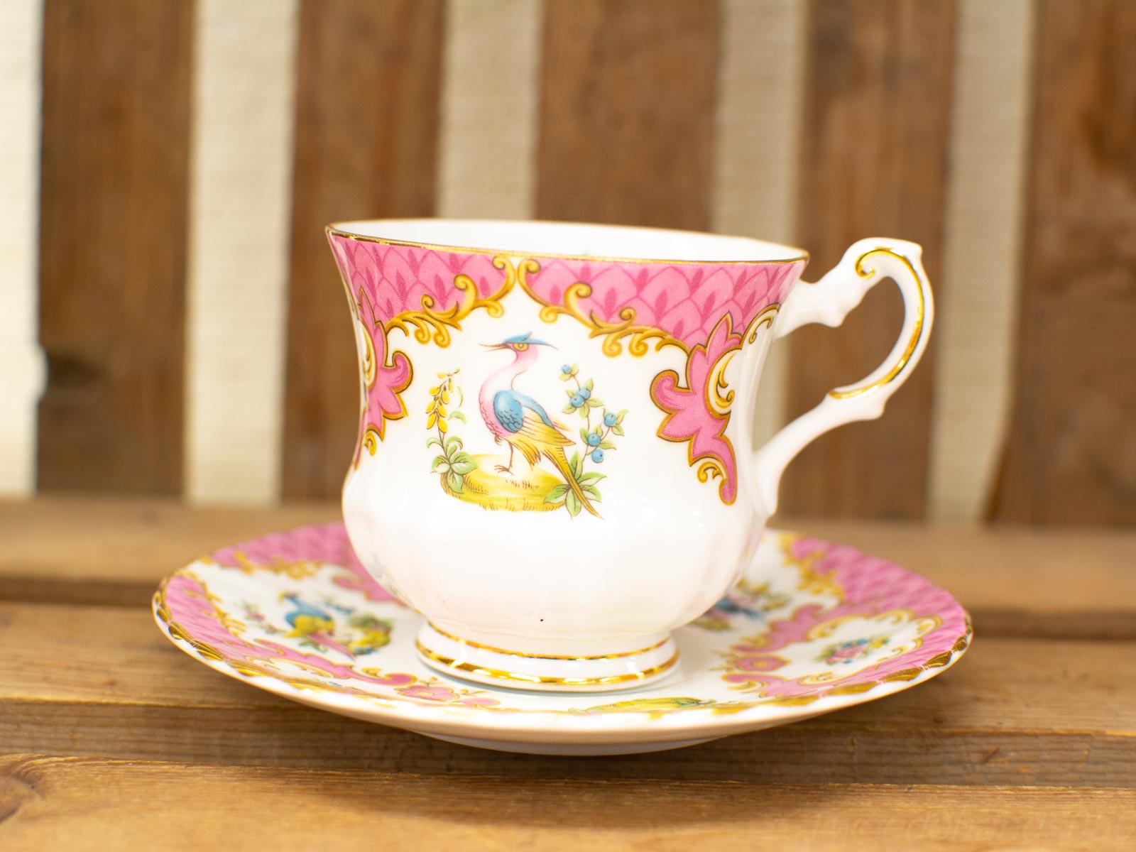 Vintage porcelain teacup and saucer set with vibrant colors and intricate designs for elegant tea time.