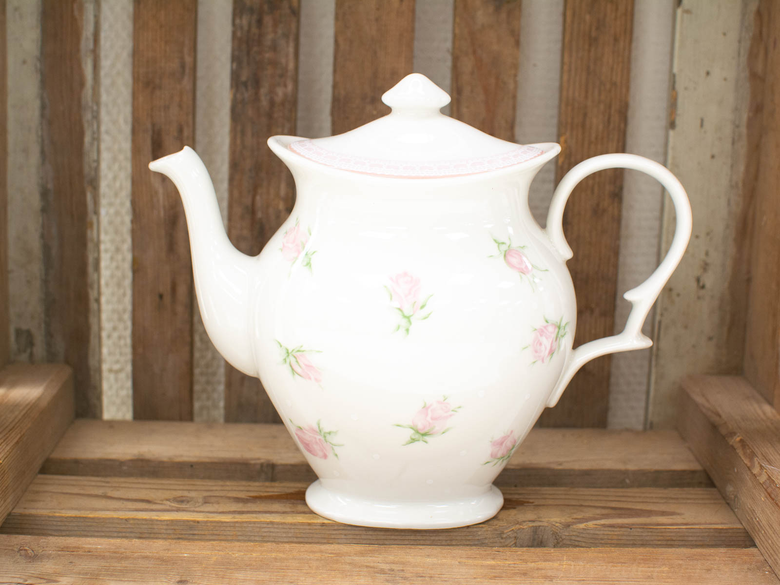 Elegant porcelain teapot with pink roses, perfect for tea parties and vintage decor.