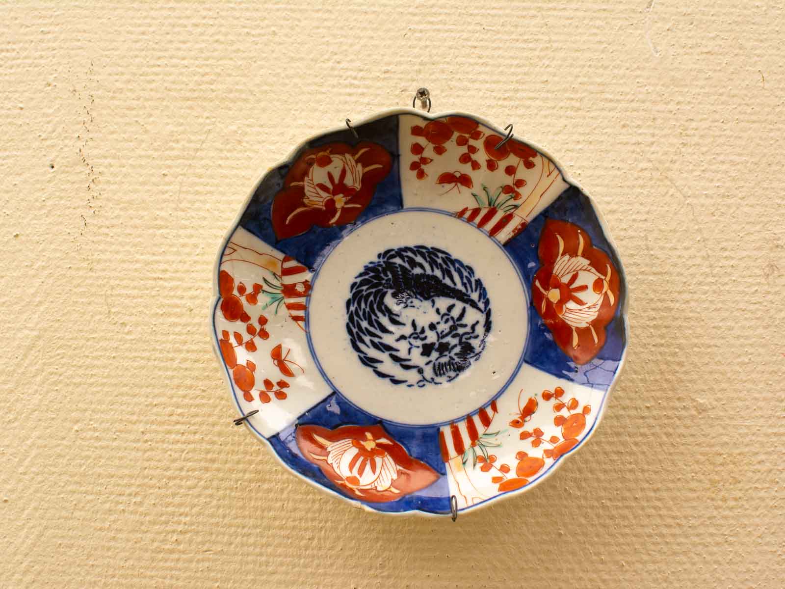 Stunning vintage ceramic plate with intricate blue and red floral designs, perfect for collectors.