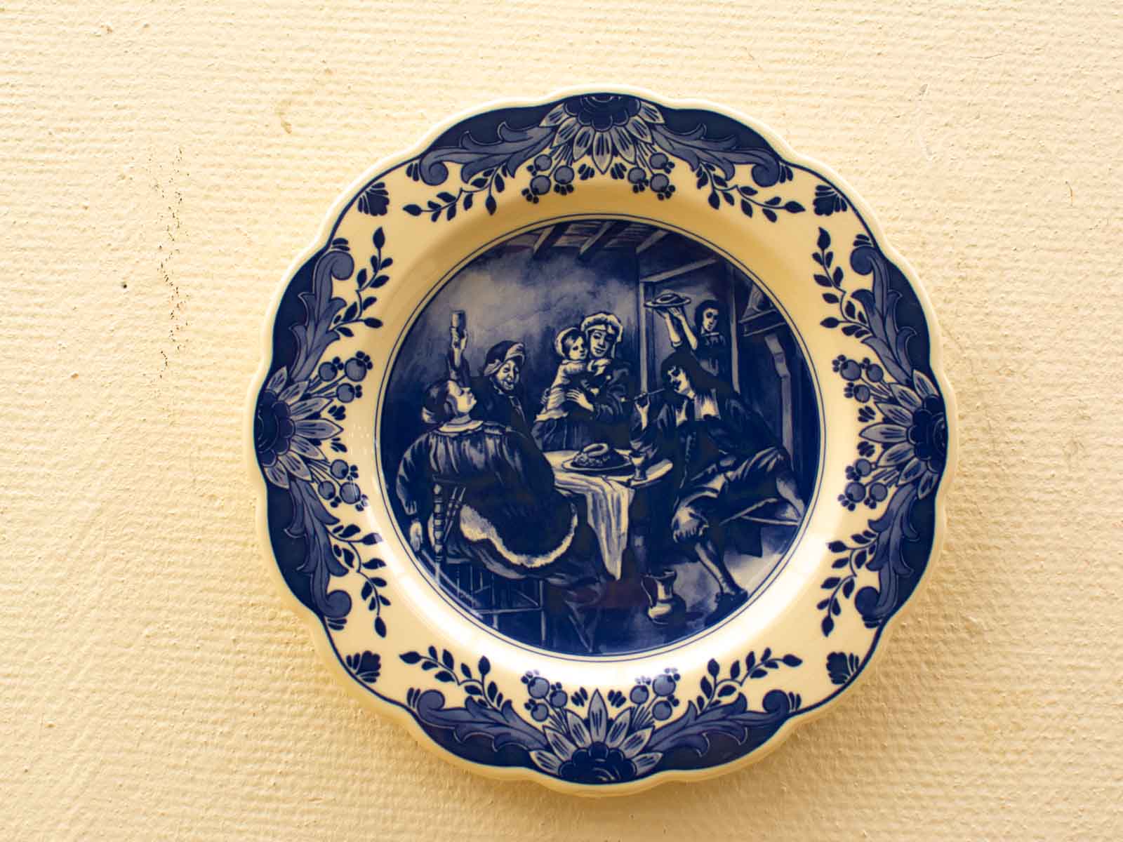 Elegant blue and white decorative plate depicting a joyful historical celebration scene.