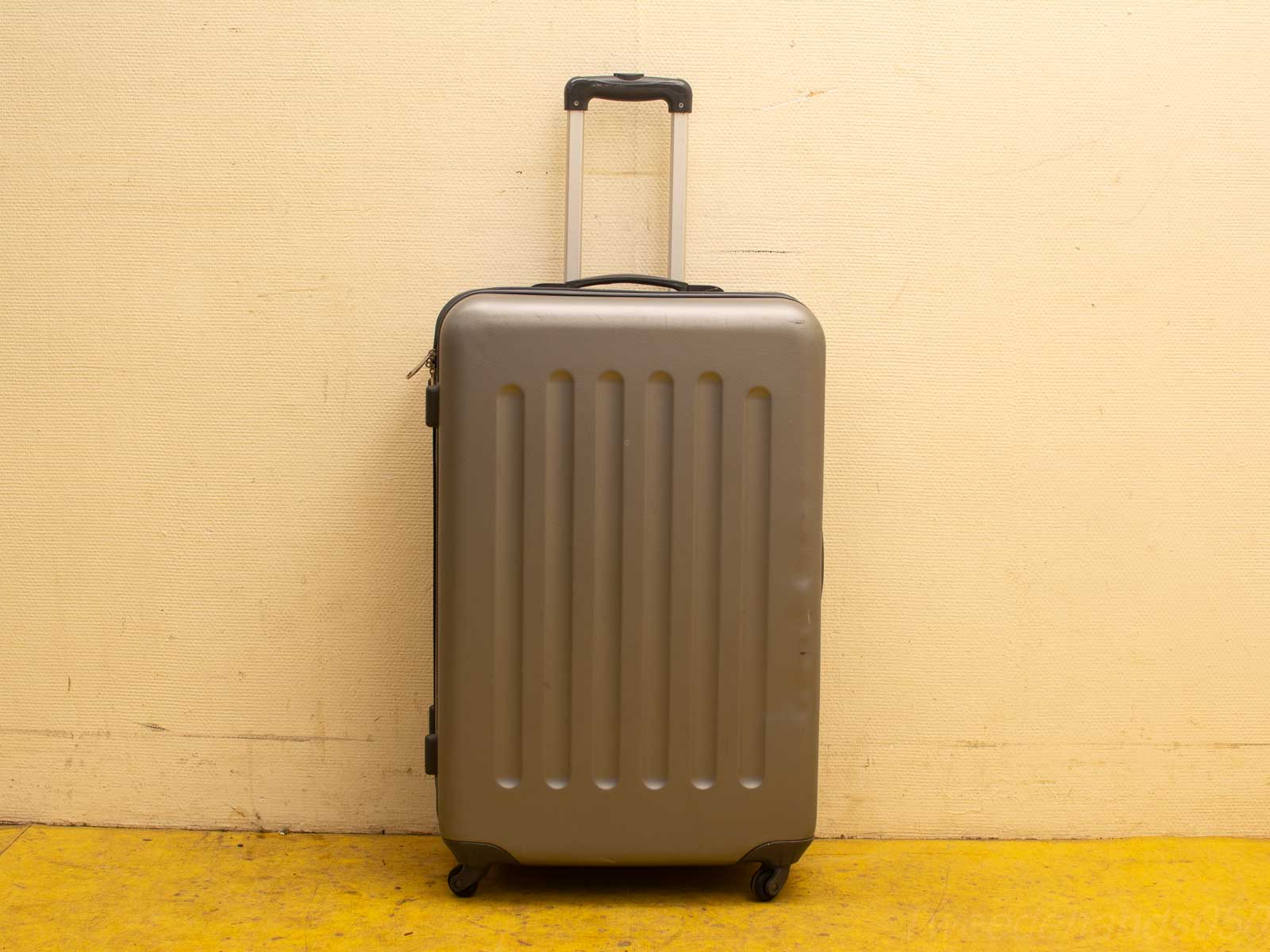 Sleek gray suitcase with wheels, designed for durability and easy travel maneuverability.