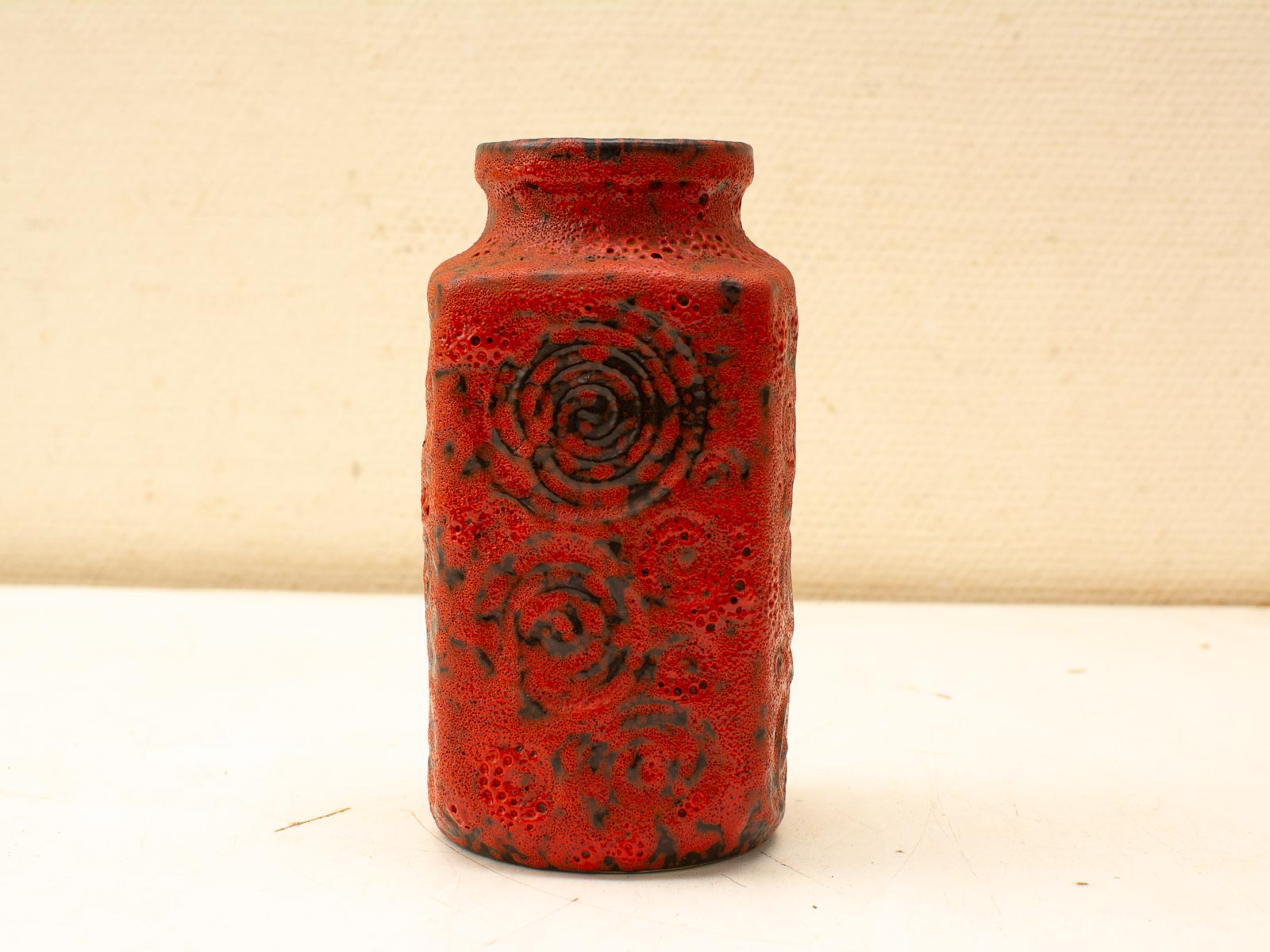 Vibrant red ceramic vase with spiral patterns, showcasing exceptional craftsmanship and artistic design.