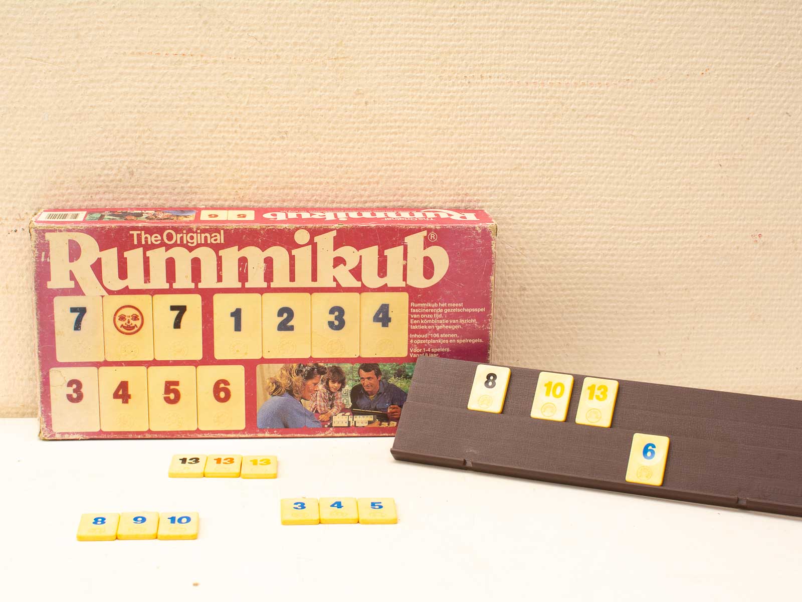 Vintage Rummikub game with classic yellow tiles and wooden rack for family fun.