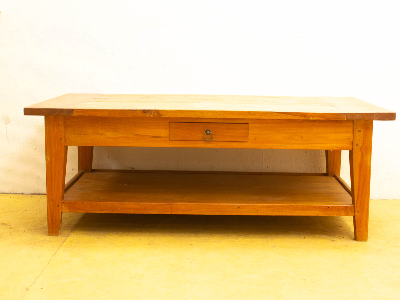 Rustic wooden coffee table with drawer and lower shelf, perfect for cozy living spaces.