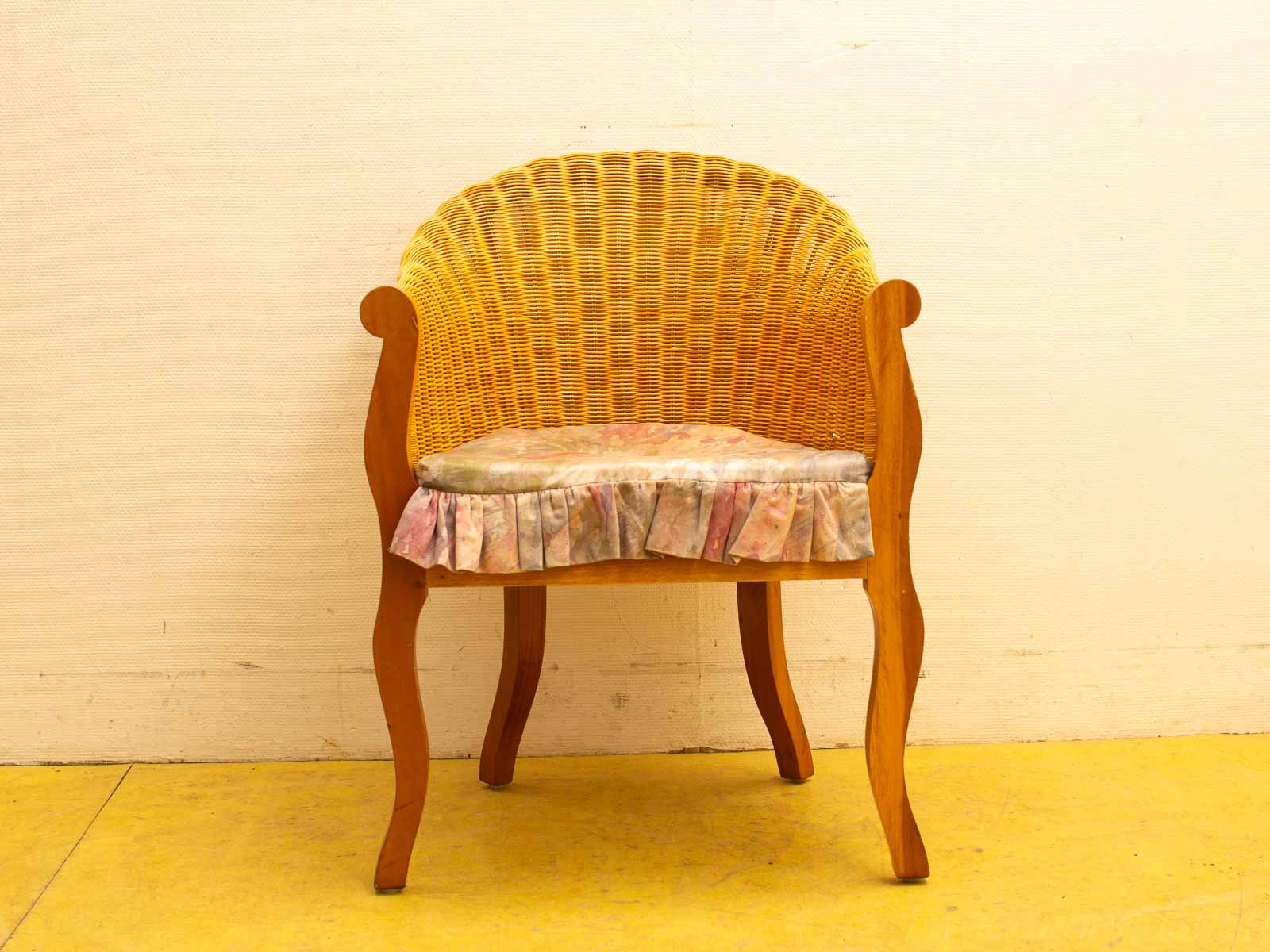 Rustic wooden chair with yellow rattan backrest and pastel cushion, adding comfort to stylish decor.