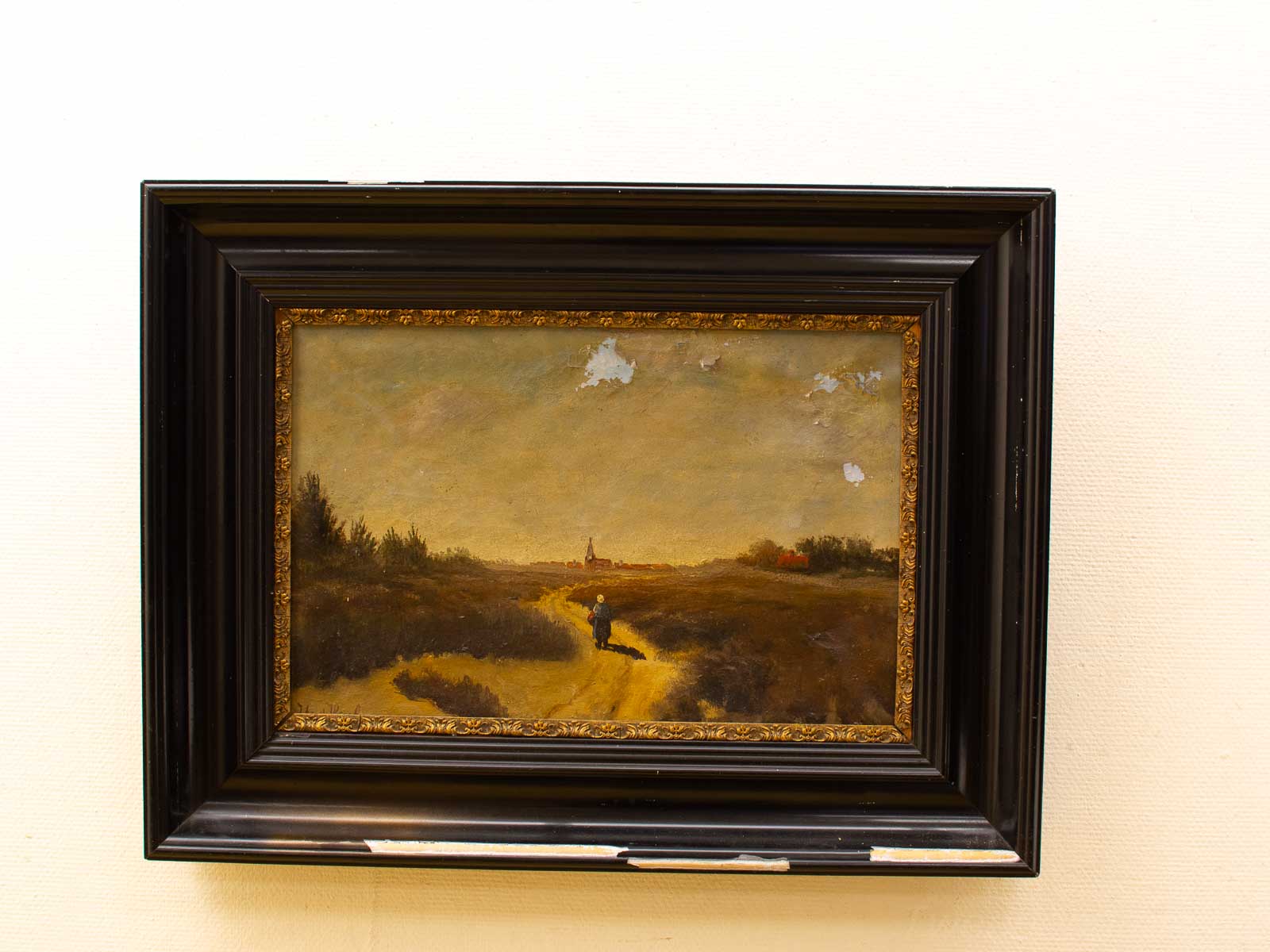 Serene countryside painting with winding path and figure, framed in ornate black and gold.