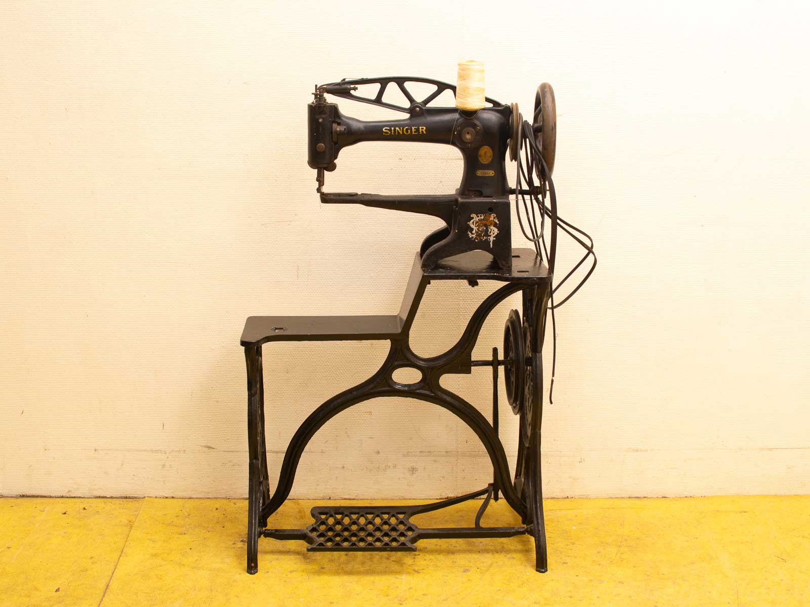 Vintage black and gold Singer treadle sewing machine, a classic blend of artistry and functionality.