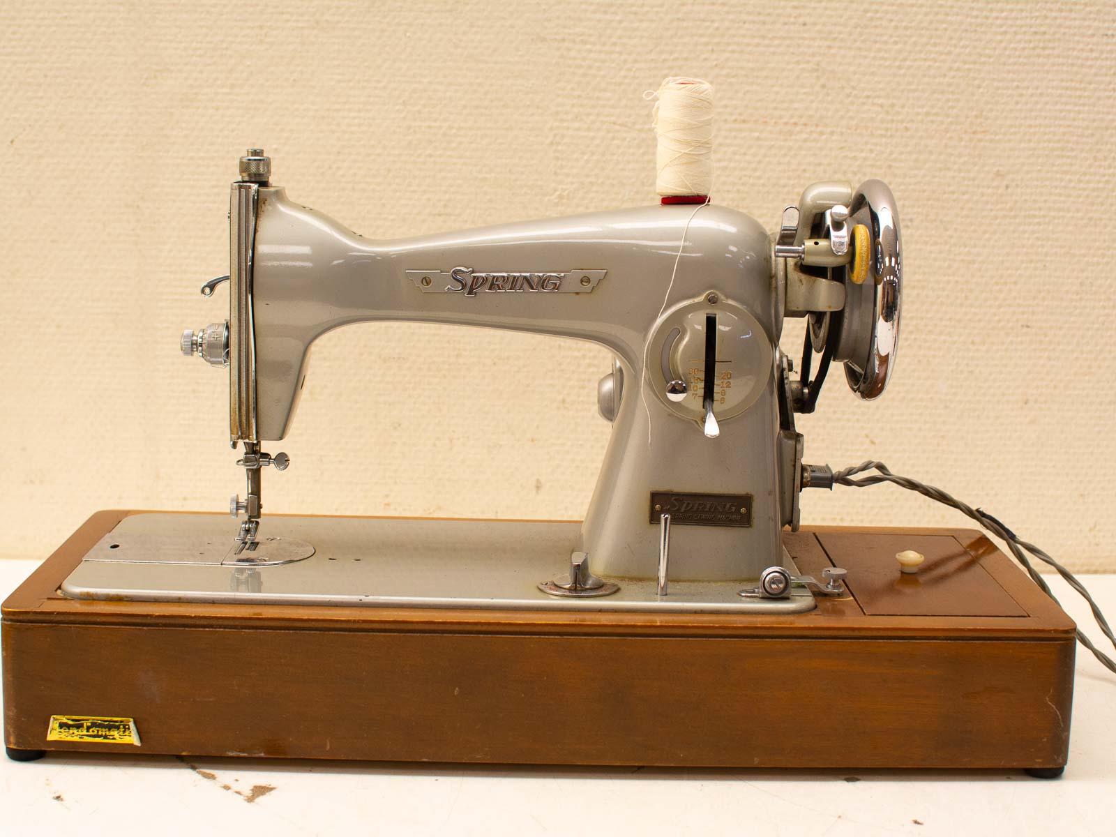 Elegant vintage sewing machine in gray with chrome accents and wooden base, perfect for enthusiasts.