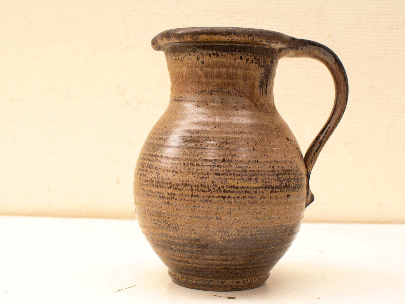 Elegant handcrafted ceramic jug in earthy tones, perfect for serving or decorative use.