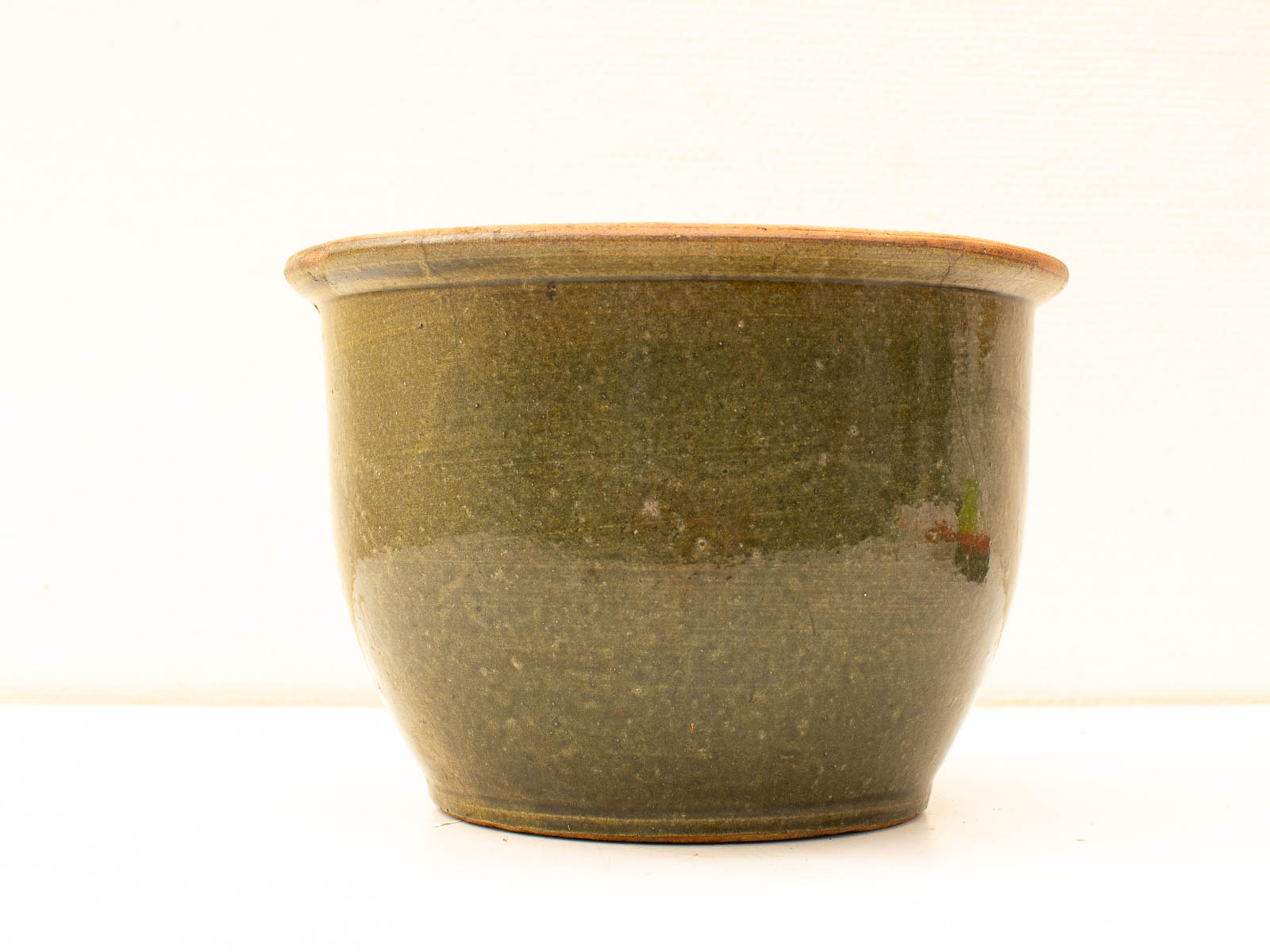 Handcrafted olive green pot with terracotta rim, perfect for vintage-inspired home decor.