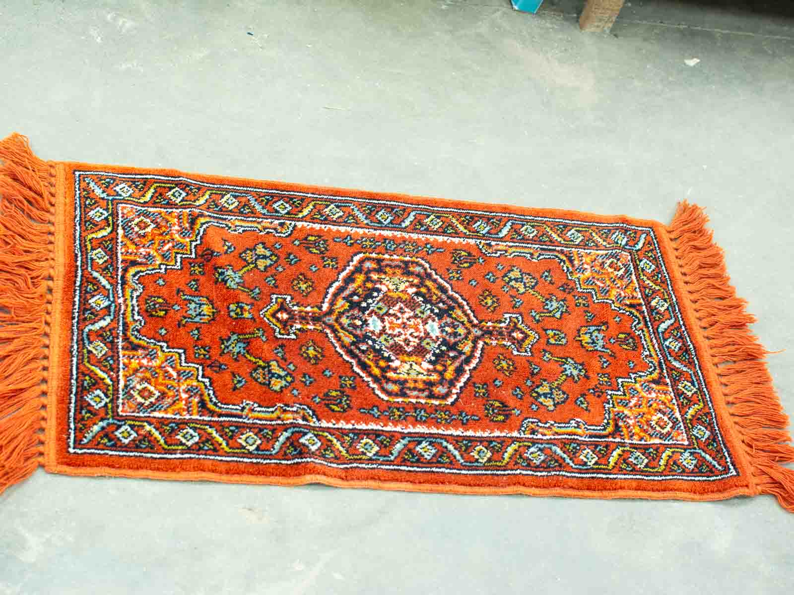 Vibrant orange vintage rug with intricate patterns, perfect for adding warmth and elegance to any space.