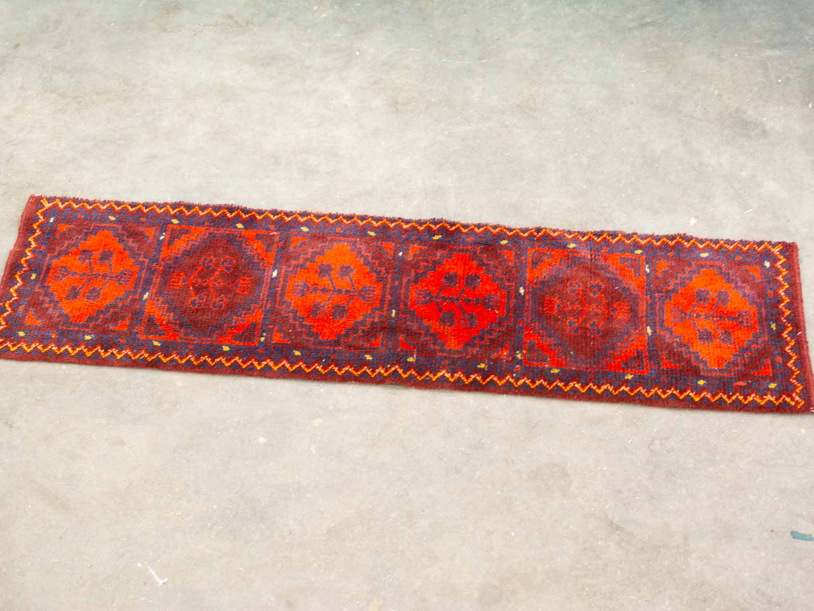 Vintage handwoven runner with red floral designs, adding warmth to hallways and entryways.