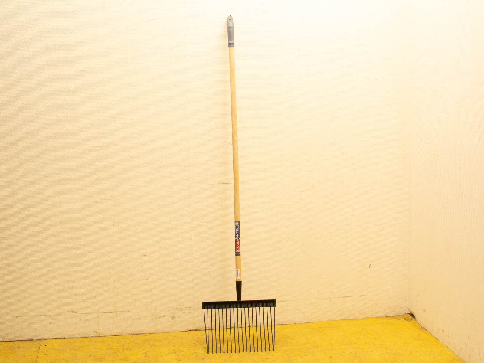 Traditional wooden garden rake with rubber grip and metal prongs for efficient yard cleanup.