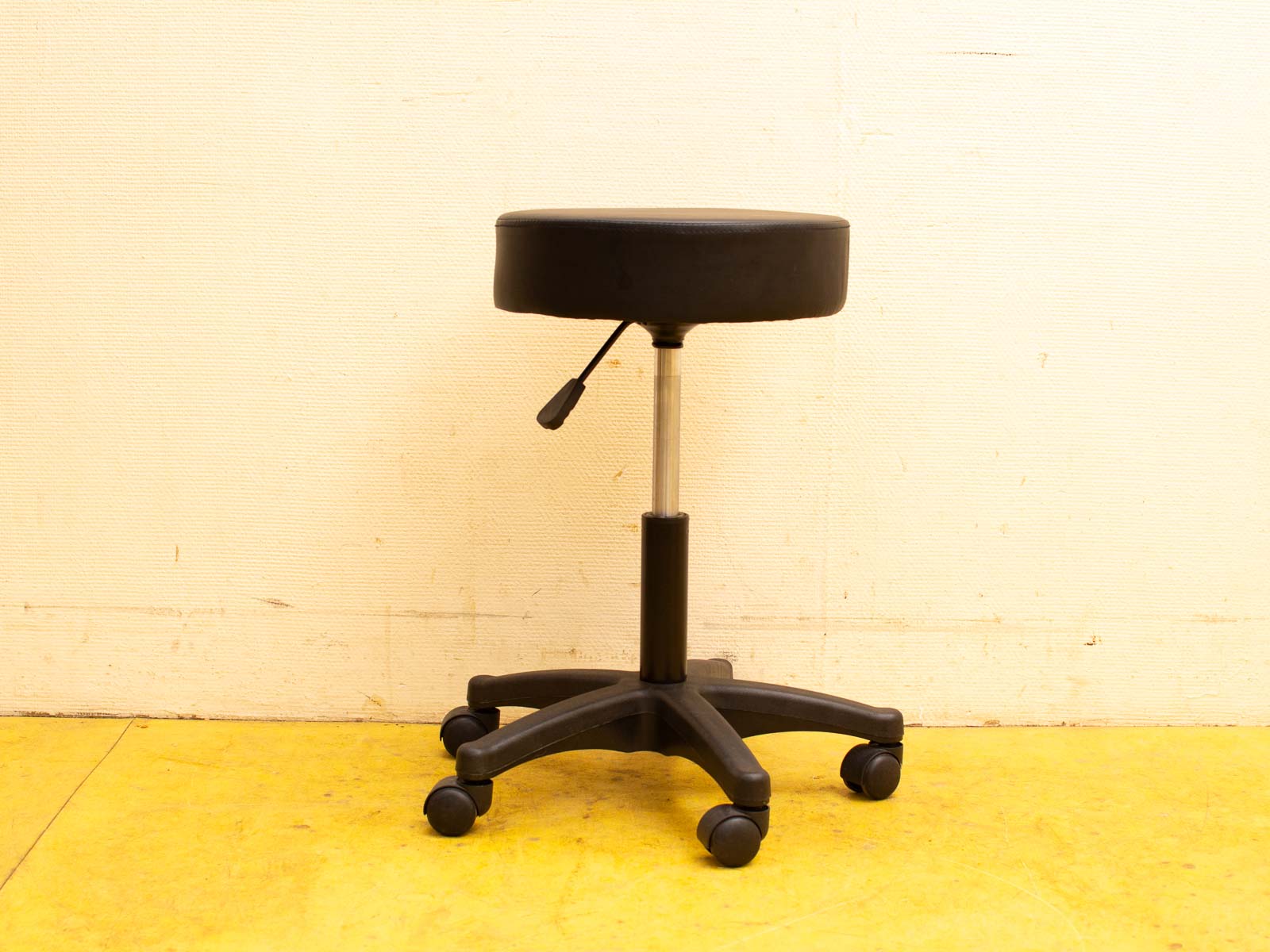 Adjustable minimalist stool with wheels, ideal for home offices and salons, combining comfort and style.