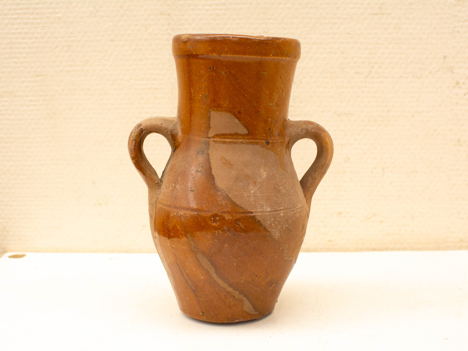 Handcrafted terracotta vase with glossy glaze finish, showcasing earthy tones and simplistic elegance.