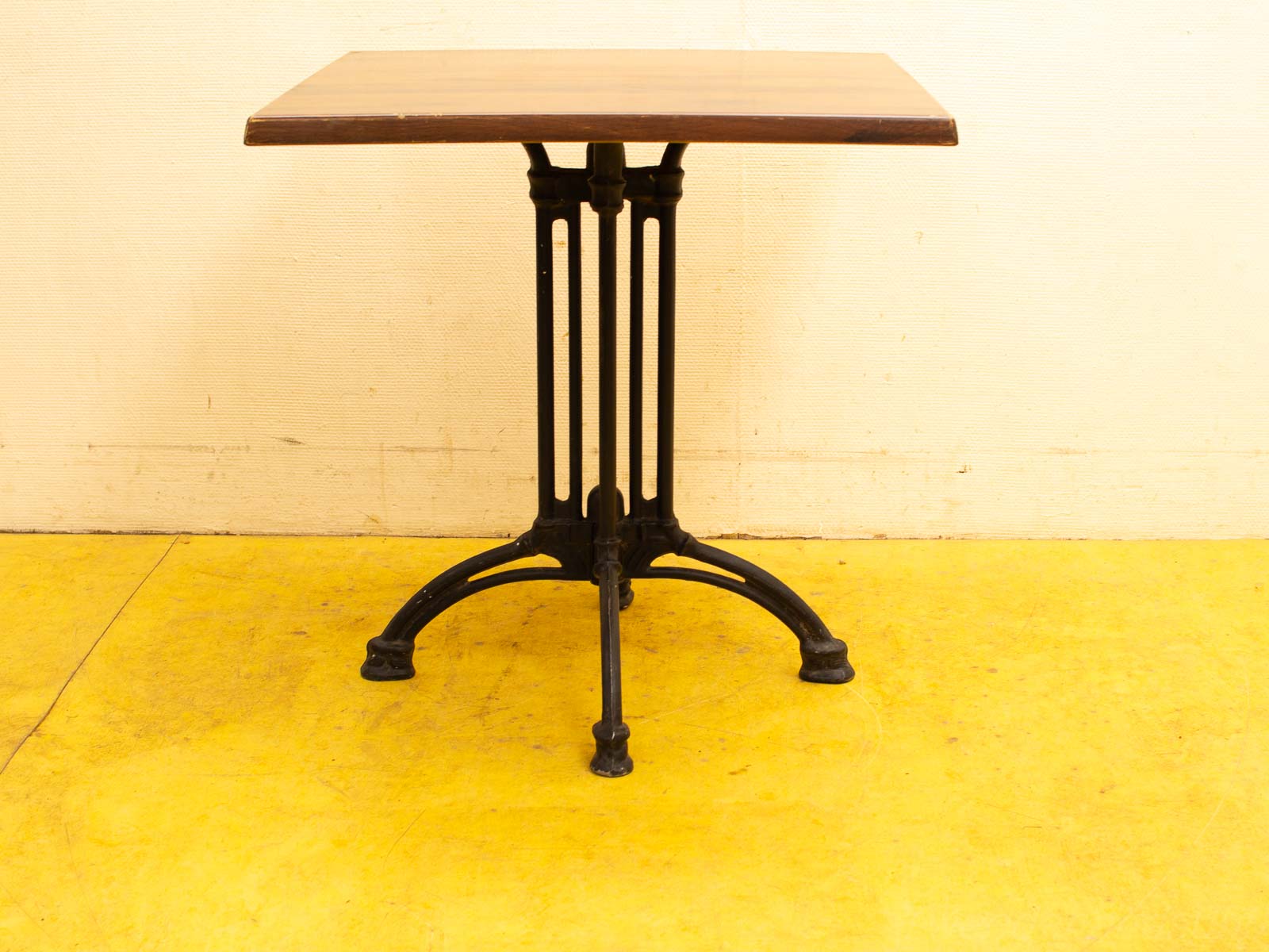 Elegant vintage wooden table with cast iron base, perfect for dining or working.