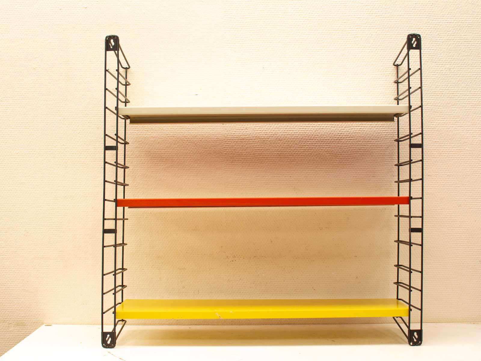 Vibrant modern minimalist shelving unit with colored shelves for stylish organization and display.