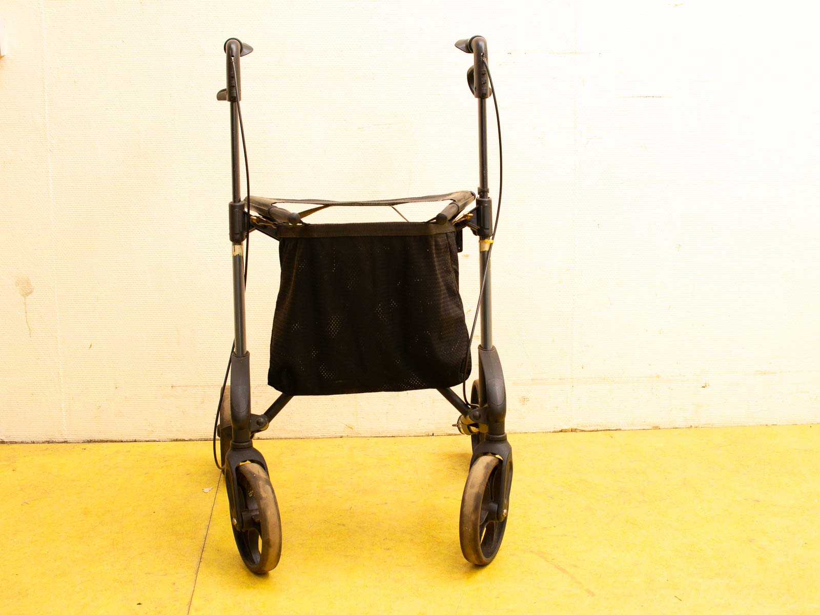 Lightweight compact walker with storage bag, ergonomic grips, and smooth wheels for mobility support.