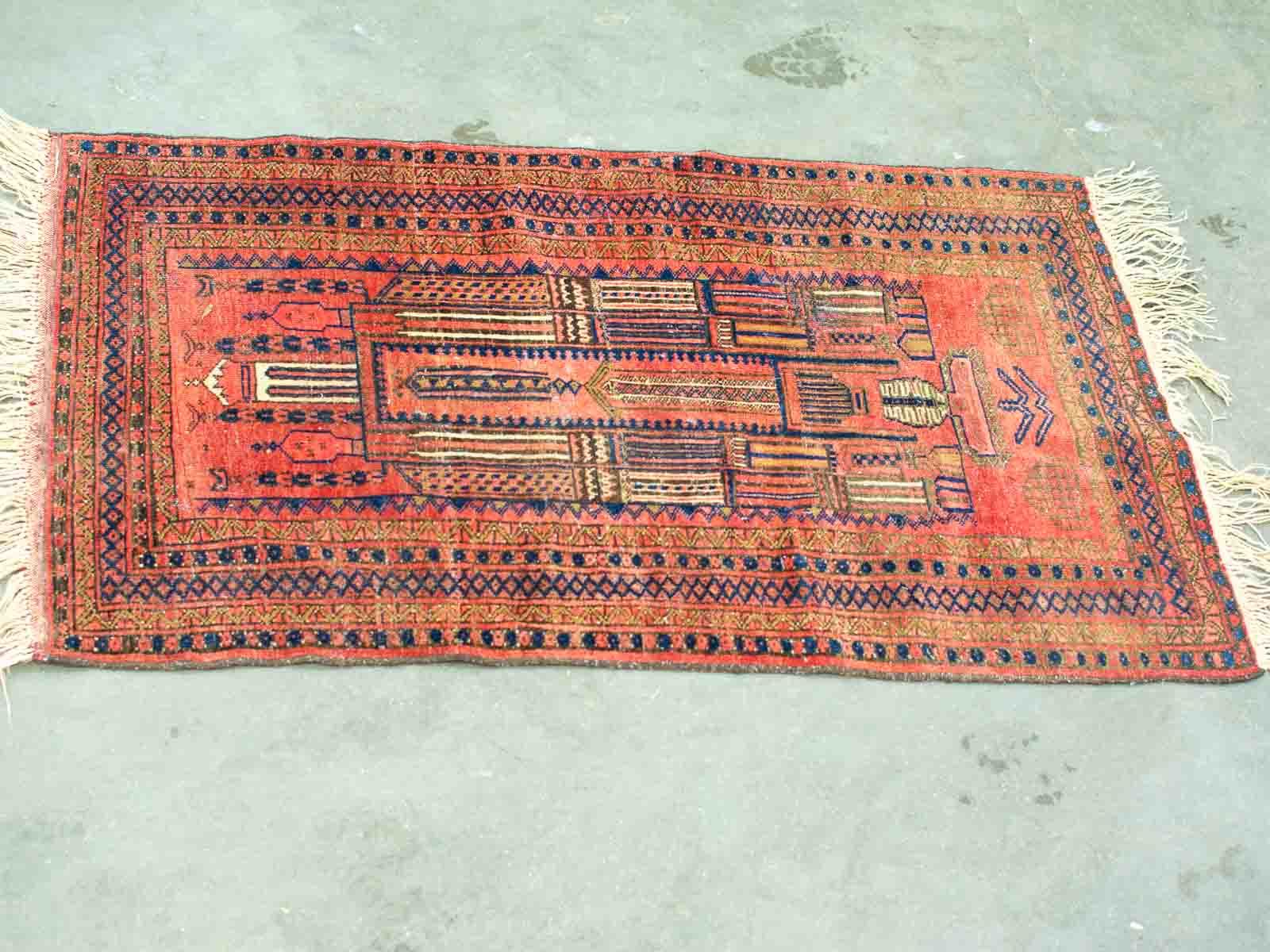 Vibrant vintage red rug with intricate geometric patterns, showcasing cultural craftsmanship and elegance.