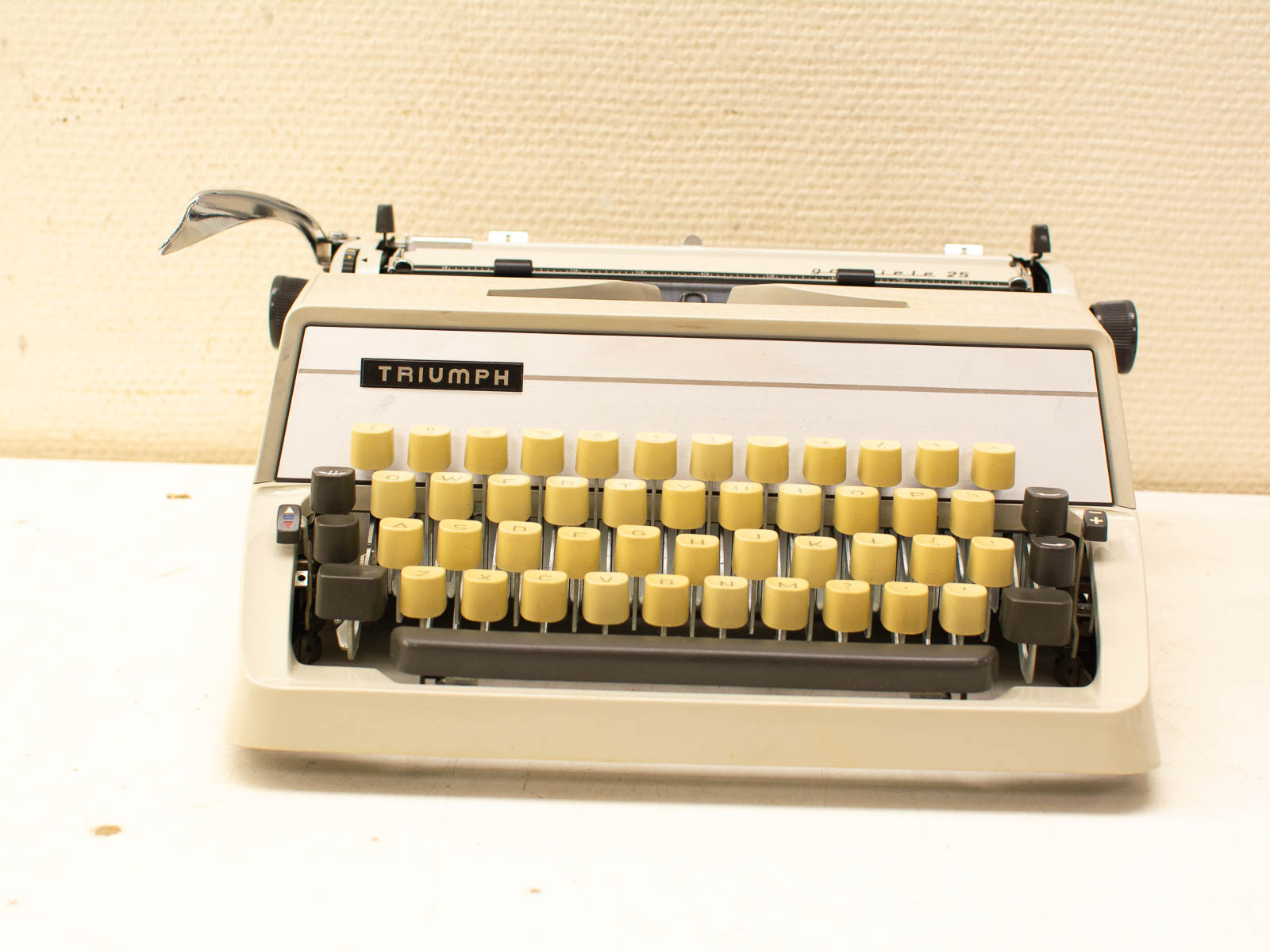 Classic Triumph typewriter in cream and yellow, embodying nostalgia and timeless craftsmanship.