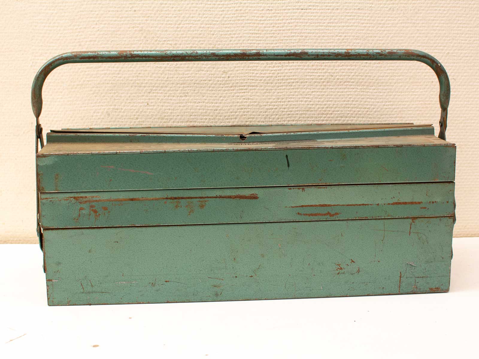 Vintage teal metal toolbox with rustic charm, perfect for collectors and tool enthusiasts.