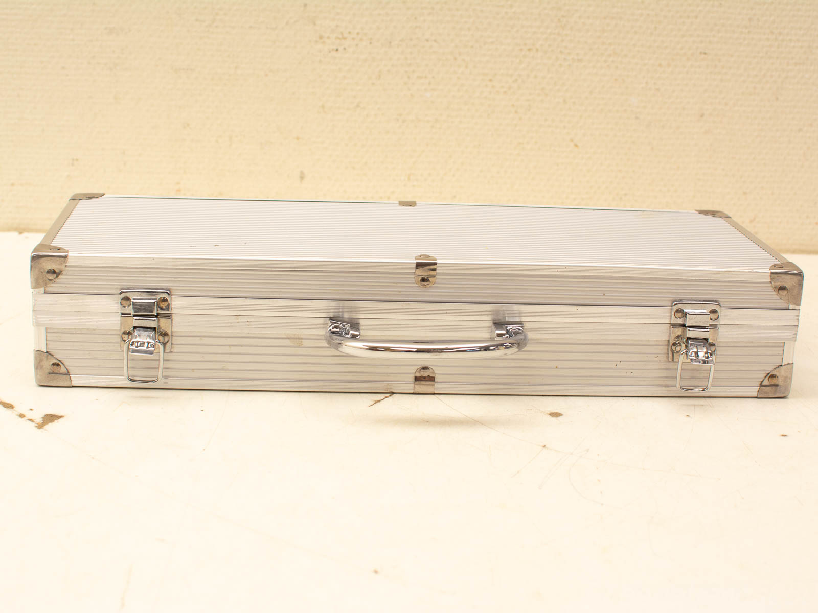 Vintage aluminum storage case with reinforced corners and polished chrome handle for secure transport.