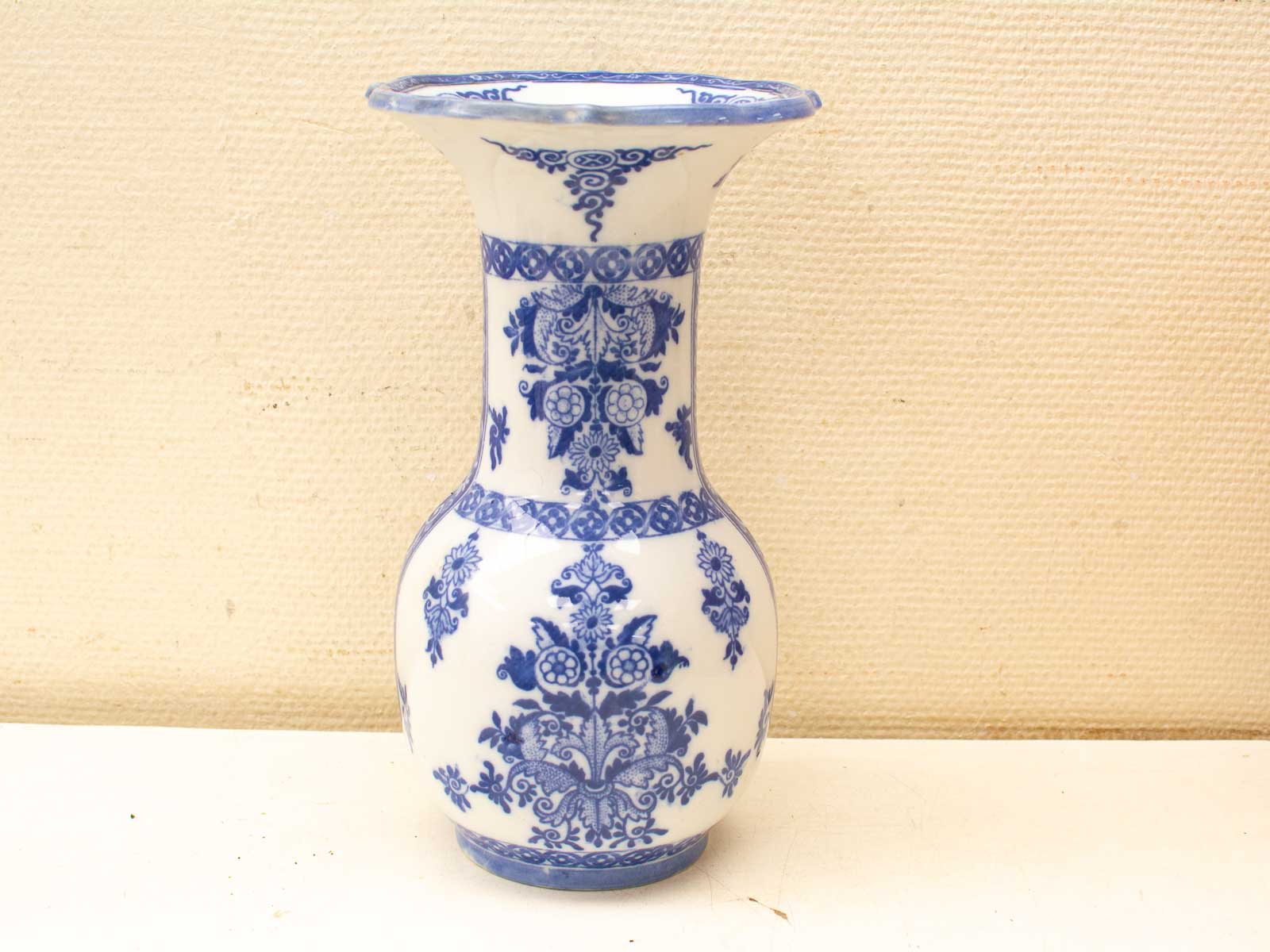 Elegant blue-and-white ceramic vase with floral motifs, perfect for home decor or flower arrangements.