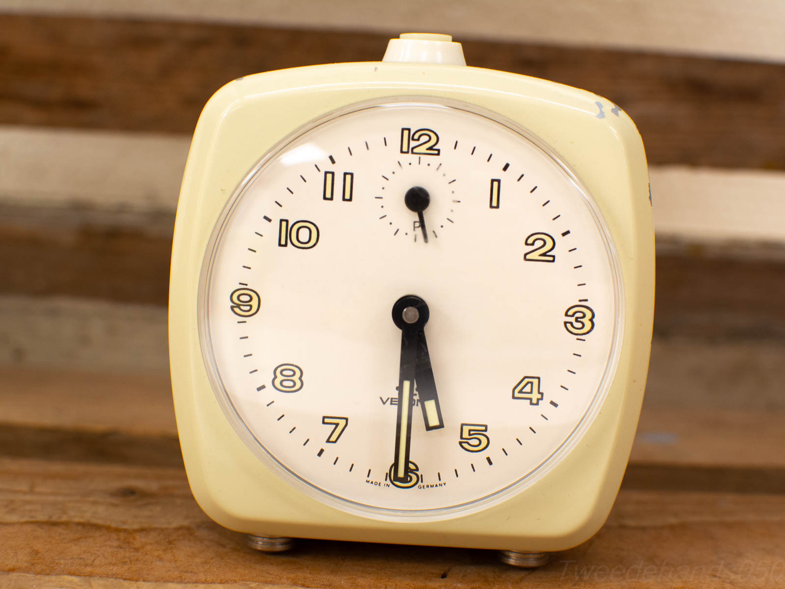 Charming vintage square alarm clock in creamy yellow, perfect for nostalgic decor and collectors.