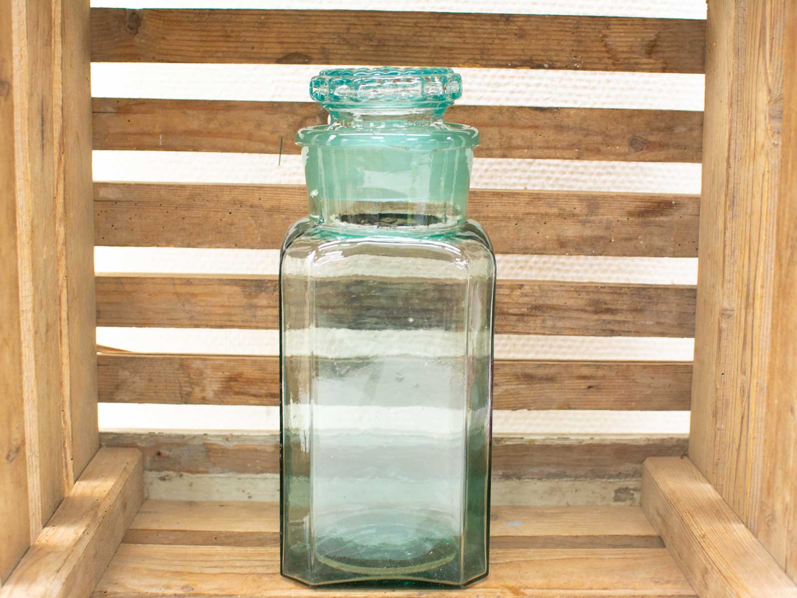 Vintage glass jar with scalloped lid, featuring a nostalgic green tint and elegant design.