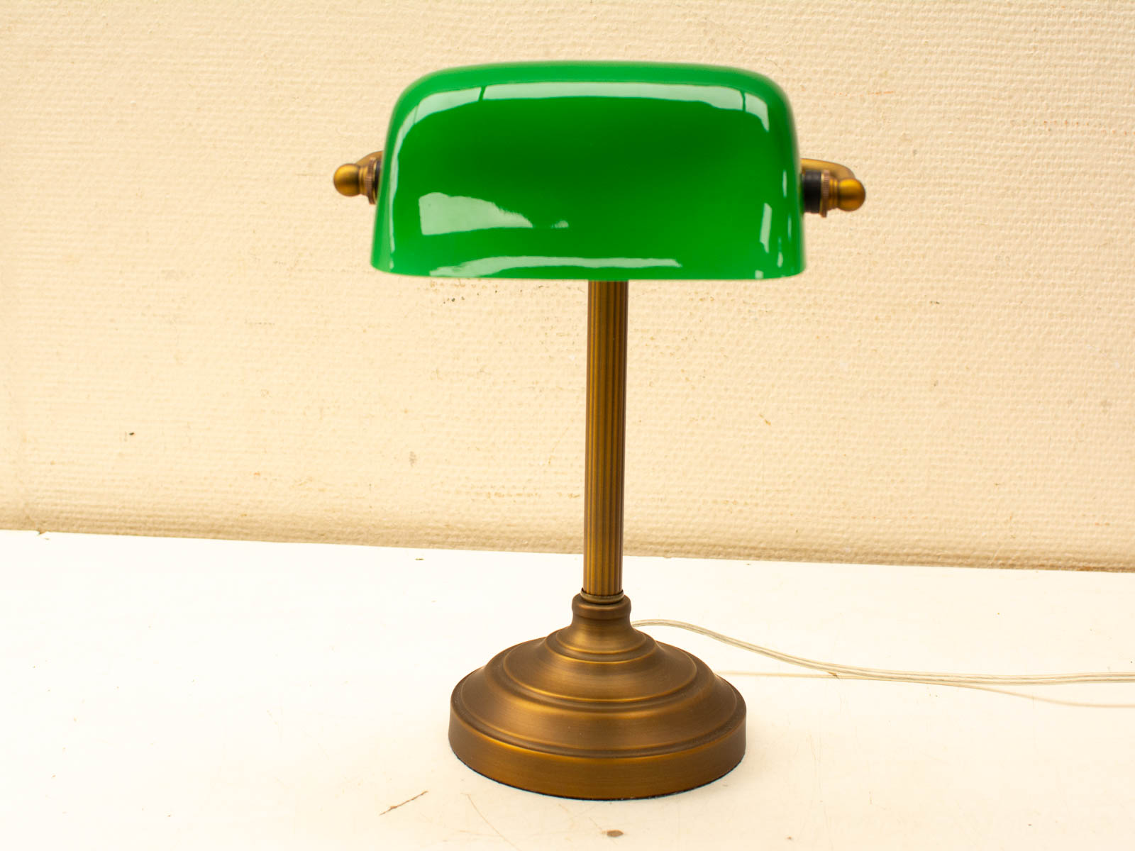 Vintage green table lamp with brass base, ideal for enhancing elegance in any interior space.