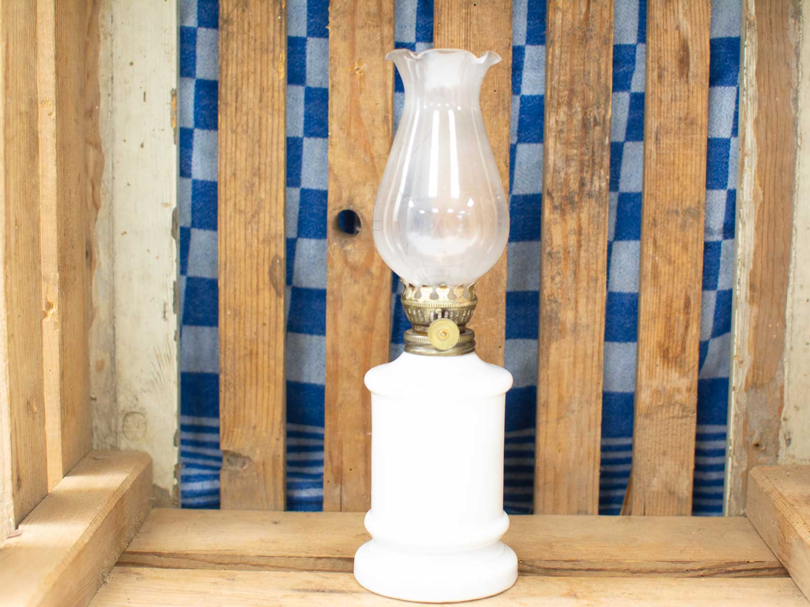 Vintage porcelain and brass oil lamp with glass chimney, perfect for charming decor.